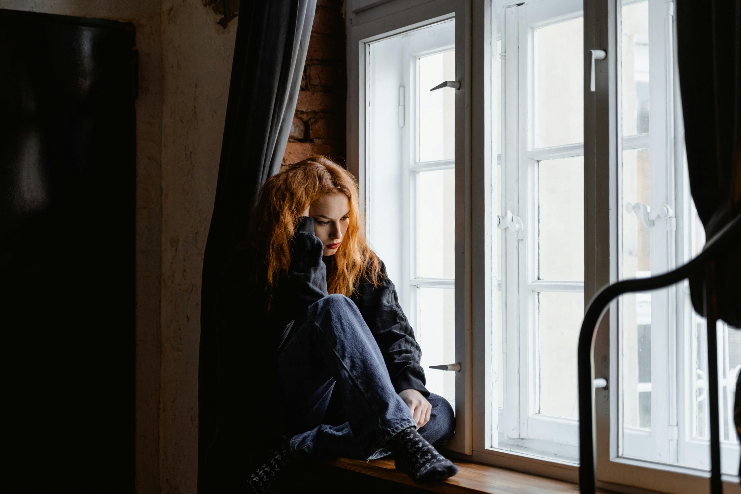 woman sitting alone by window