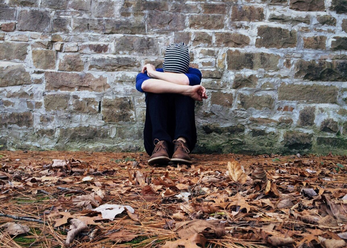 man sitting by wall