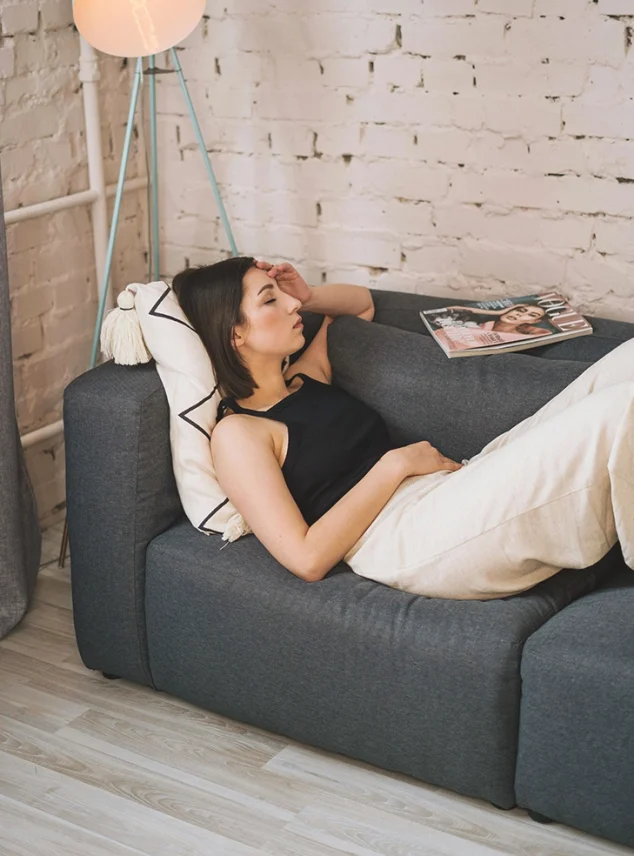 A woman looking stressed on a couch