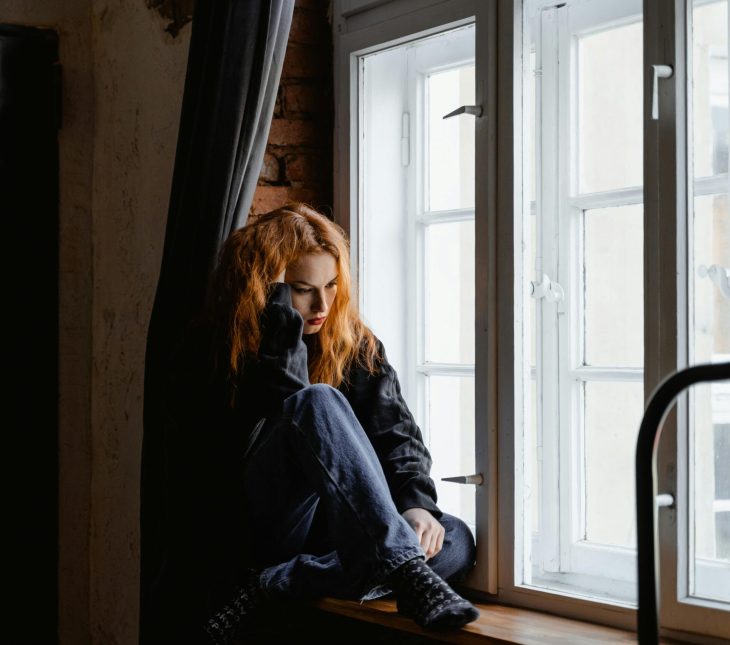 woman sitting alone by window