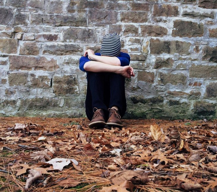 man sitting by wall